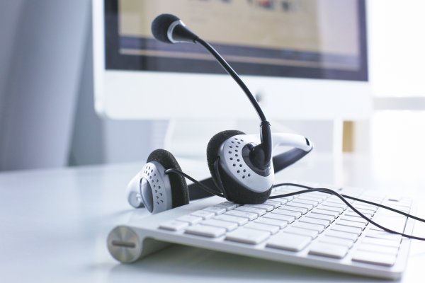 voip services best voip providers computer with headset on white keyboard monitor in the background